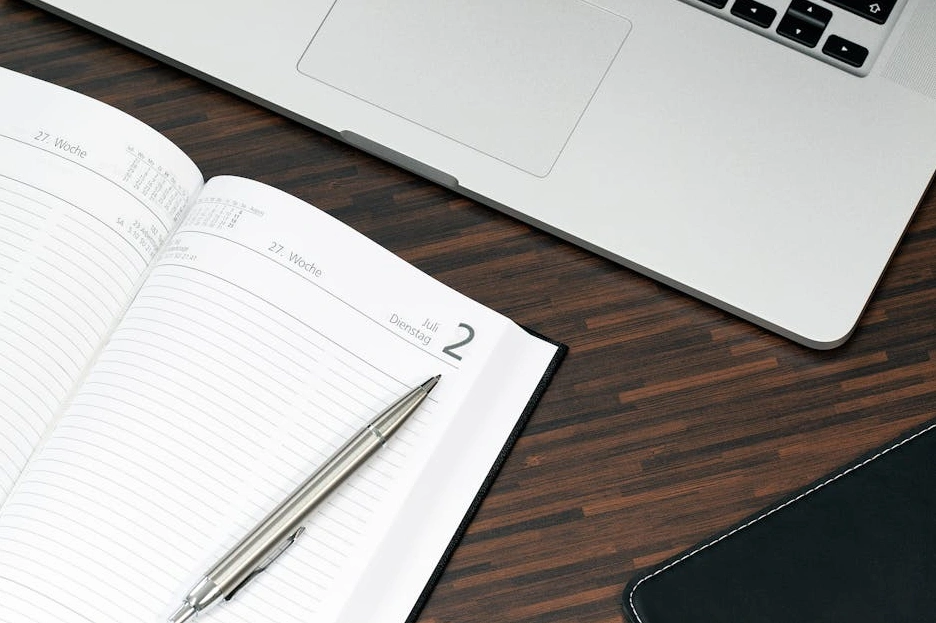 Persona che scrive appunti strategici in un elegante taccuino